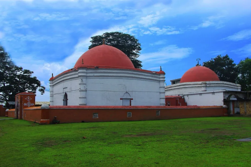 White domed tomb of Khan Jahan Ali with red domes under a blue sky