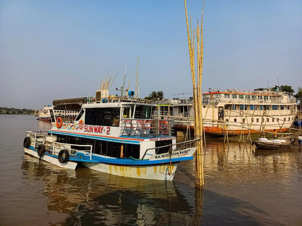 Passenger launches and a tourist boat moored on the Rupsa river at Khulna