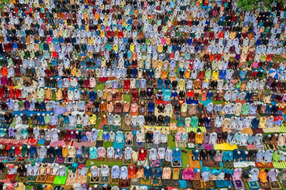 Aerial view of rows of worshippers in colourful clothes at the Sholakia Eid congregation