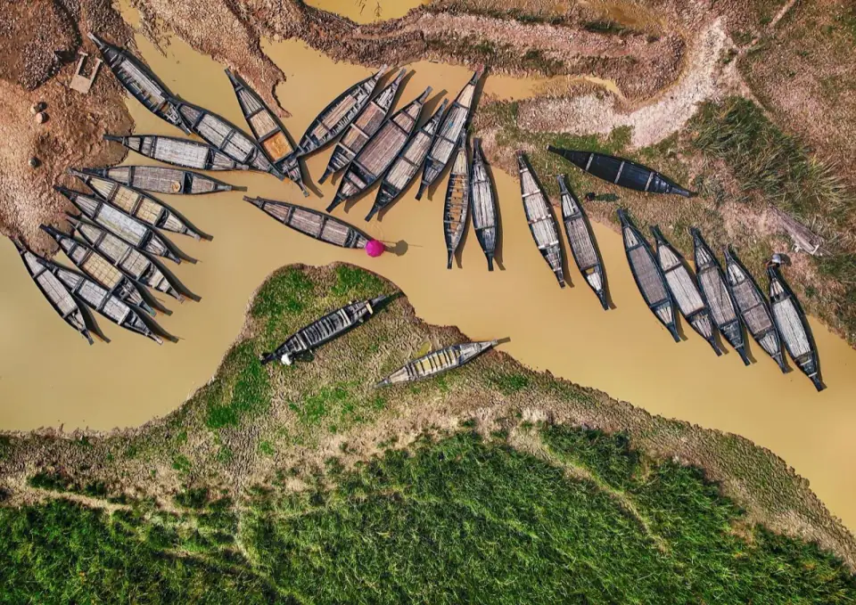 Aerial view of wooden boats moored along a channel at Ratargul in the dry season